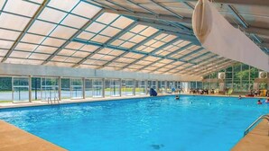 An indoor swimming pool with a glass ceiling, clear poolside, and multiple lanes. - Dwell and Wander Stay (Ellijay)