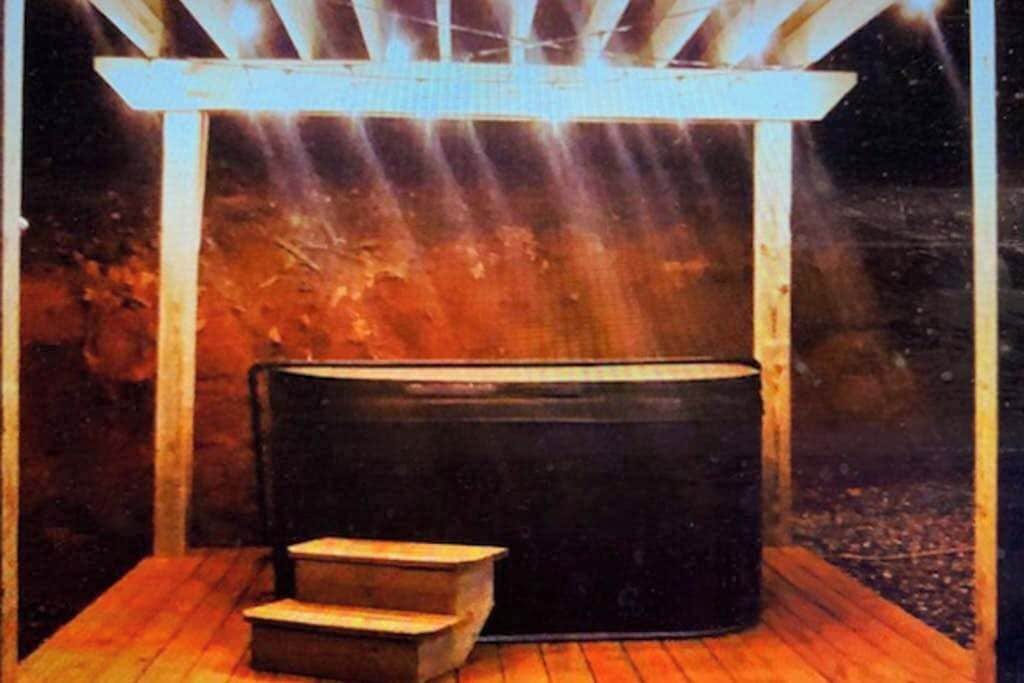 A sauna with a wooden bench and steps, a wooden structure above, and a dark background.