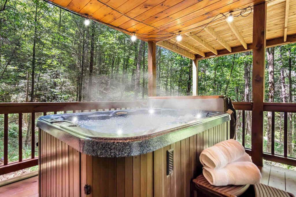 A hot tub on a wooden deck with a forest view.