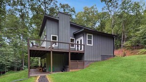 A modern two-story house with a covered porch and a stone pathway leading to the entrance. - The Hidden Haven Stay (Blue Ridge)