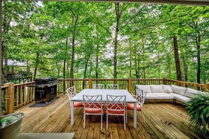 A wooden deck with a table and chairs, a grill, and a sofa. - Bungalow Blue Retreat (Blue Ridge)