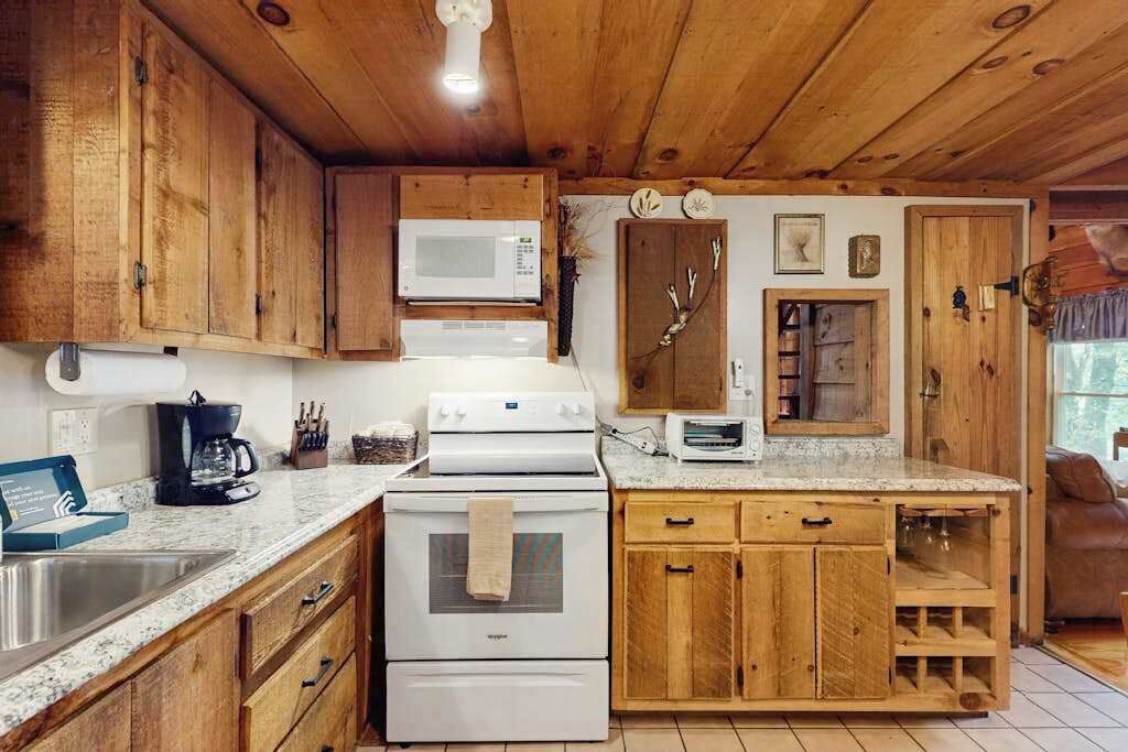 A kitchen with wooden cabinets, a microwave, a stove, and a toaster.