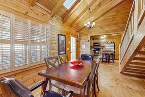 Un intérieur en bois comprenant un coin repas, une cuisine et un escalier.