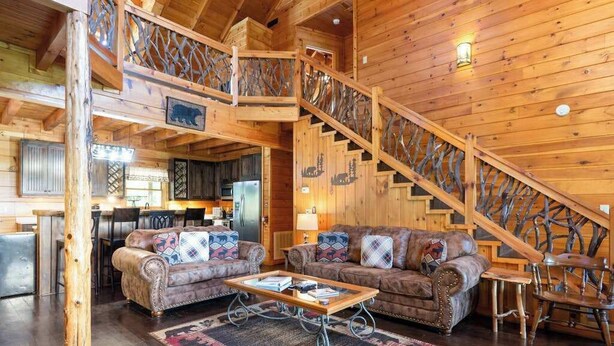 A wooden interior with a staircase, a sofa set, and a dining area. - Roscoe's Retreat Stay (Blue Ridge)