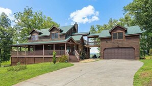 A two-story wooden house with a covered porch, a garage, and a driveway. - Roscoe's Retreat Stay (Blue Ridge)