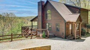Una baita di legno con un portico, un camino e una piccola terrazza.