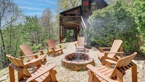 Una baita con veranda, un braciere e poltrone Adirondack.