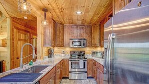 Una cucina moderna con mobili in legno, elettrodomestici in acciaio inossidabile e pavimento in piastrelle a spina di pesce.