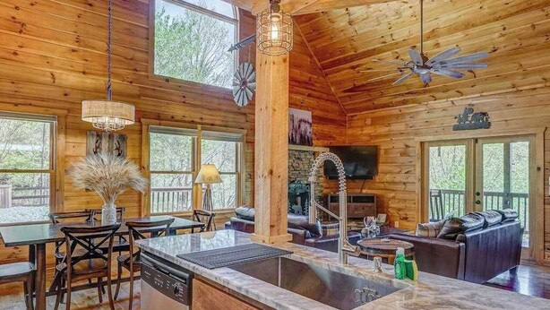 Interno di una baita di legno con cucina, sala da pranzo e soggiorno.