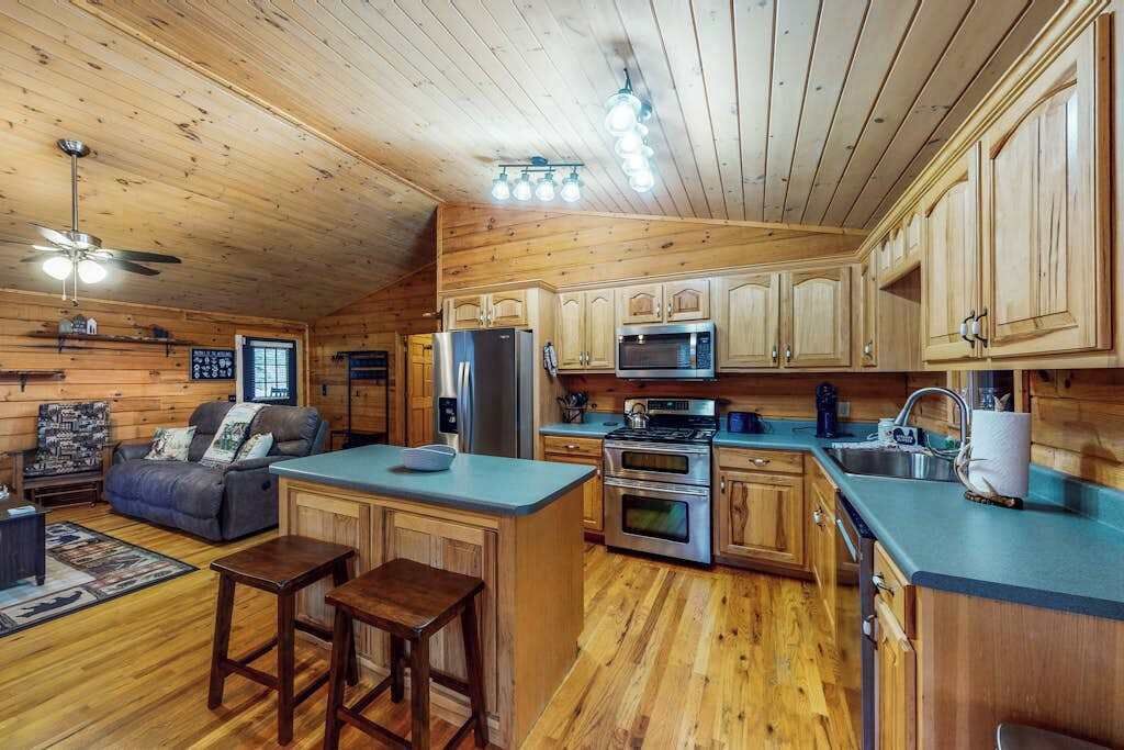 L’intérieur d’une cabane comprenant une cuisine, un coin repas et un salon.