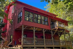 A red wooden cabin with a balcony and a deck. - It's a Wonderful Life (Sautee Nacoochee)