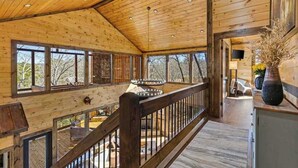 A wooden interior with a balcony, large windows, and a staircase. - Hope Haven Blue Ridge (Blue Ridge)