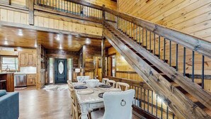 A wooden interior with a dining area, staircase, and kitchen. - Hope Haven Blue Ridge (Blue Ridge)