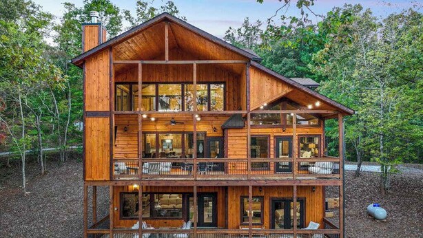A multi-story wooden cabin with large windows, balconies, and a deck area. - Hope Haven Blue Ridge (Blue Ridge)