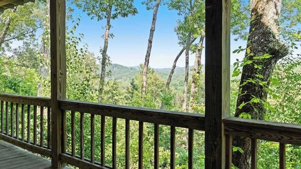 A wooden deck with a view of a forested landscape. - Mountain Rivers Lodge (Mineral Bluff)