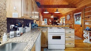 Una cucina con mobili in legno, piani di lavoro in granito, un forno e un lavello.
