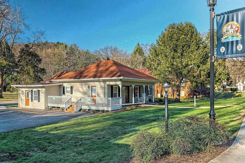 Ein eingeschossiges Haus mit Veranda, einer kleinen angebauten Garage und einem gepflegten Rasen.