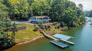 Une maison au bord du lac, avec un quai et une zone abritée.
