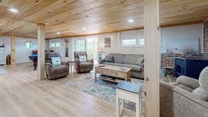 Un salon spacieux doté d’un plancher en bois, d’une cheminée et d’un coin salon confortable.