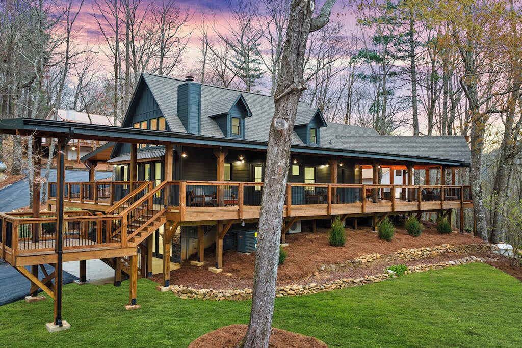 Eine Lodge mit Terrasse, mehreren Zimmern und einem Steinfundament.