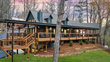 Eine Lodge mit Terrasse, mehreren Zimmern und einem Steinfundament.