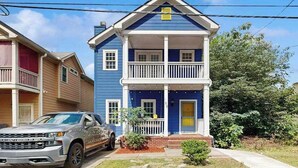 Une maison à deux étages avec un porche à l’avant, un garage et une allée.