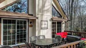 A deck with outdoor furniture, a large window, and a door. - The Bird House Stay - Firepit and Grill (Dillard)