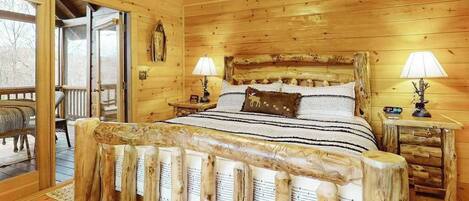 A wooden cabin bedroom with a bed, two bedside tables, and a window.