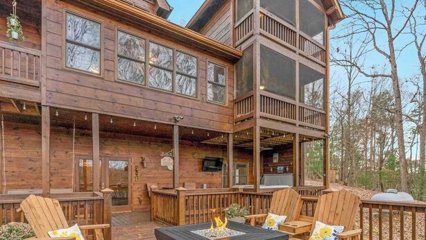 A two-story wooden cabin with a deck, outdoor seating, and a fire pit. - Copper Lantern Stays (Ellijay)