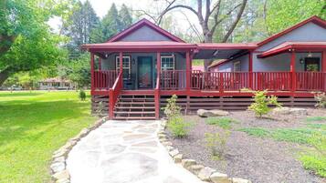 A two-story house with a porch, a stone pathway, and a well-maintained garden.