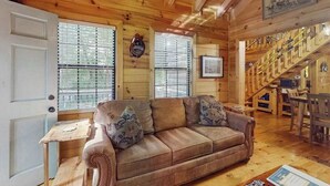 A wooden interior with a sofa, a small table, and a staircase. - Swiss Puure Huus Cabin (Blue Ridge)