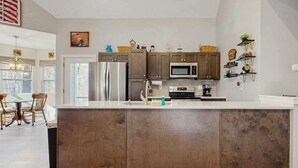 Eine moderne Küche mit Holzausstattung, Edelstahlgeräten und einer großen Kochinsel.