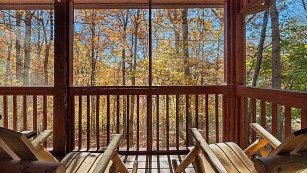 Eine Holzterrasse mit Blick auf einen Wald.