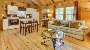 A cozy cabin interior with a dining area, kitchen, and living room.