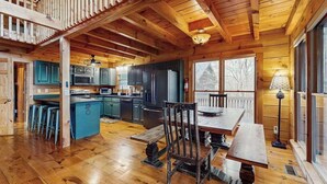 L’intérieur d’un chalet en bois comprend une cuisine, un coin repas et un balcon.