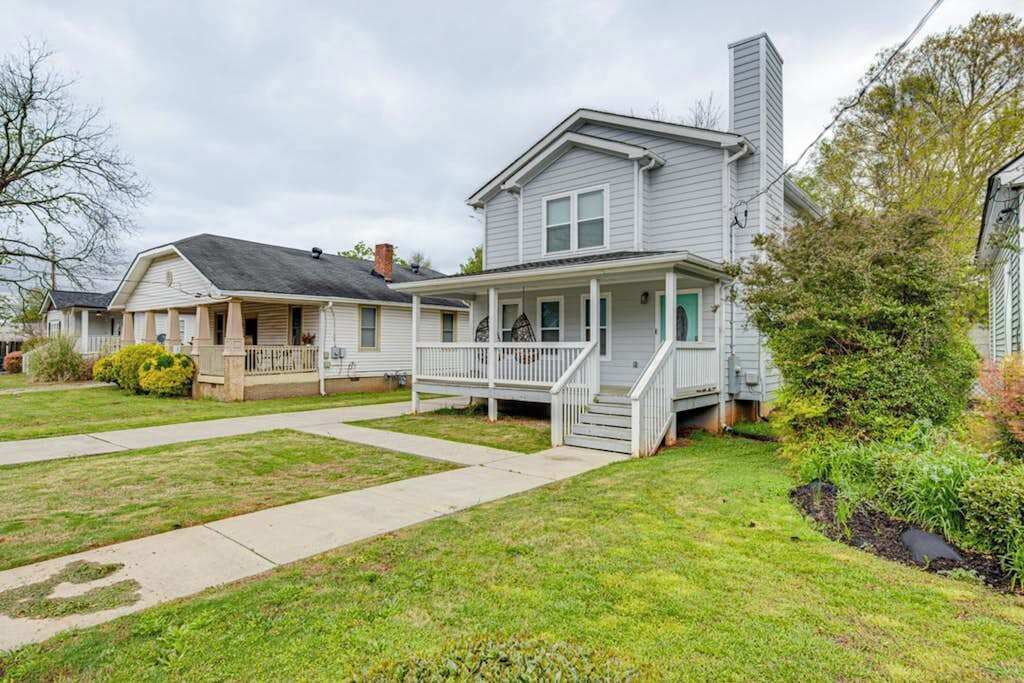 A two-story house with a front porch, a covered entryway, and a visible staircase leading to the second floor.