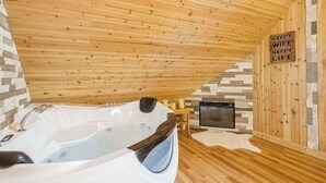 A sauna room with a wooden ceiling, a stone wall, a fireplace, and a sign that reads 'HAPPY WIFE HAPPY LIFE'. - House of Views Getaway (Blue Ridge)
