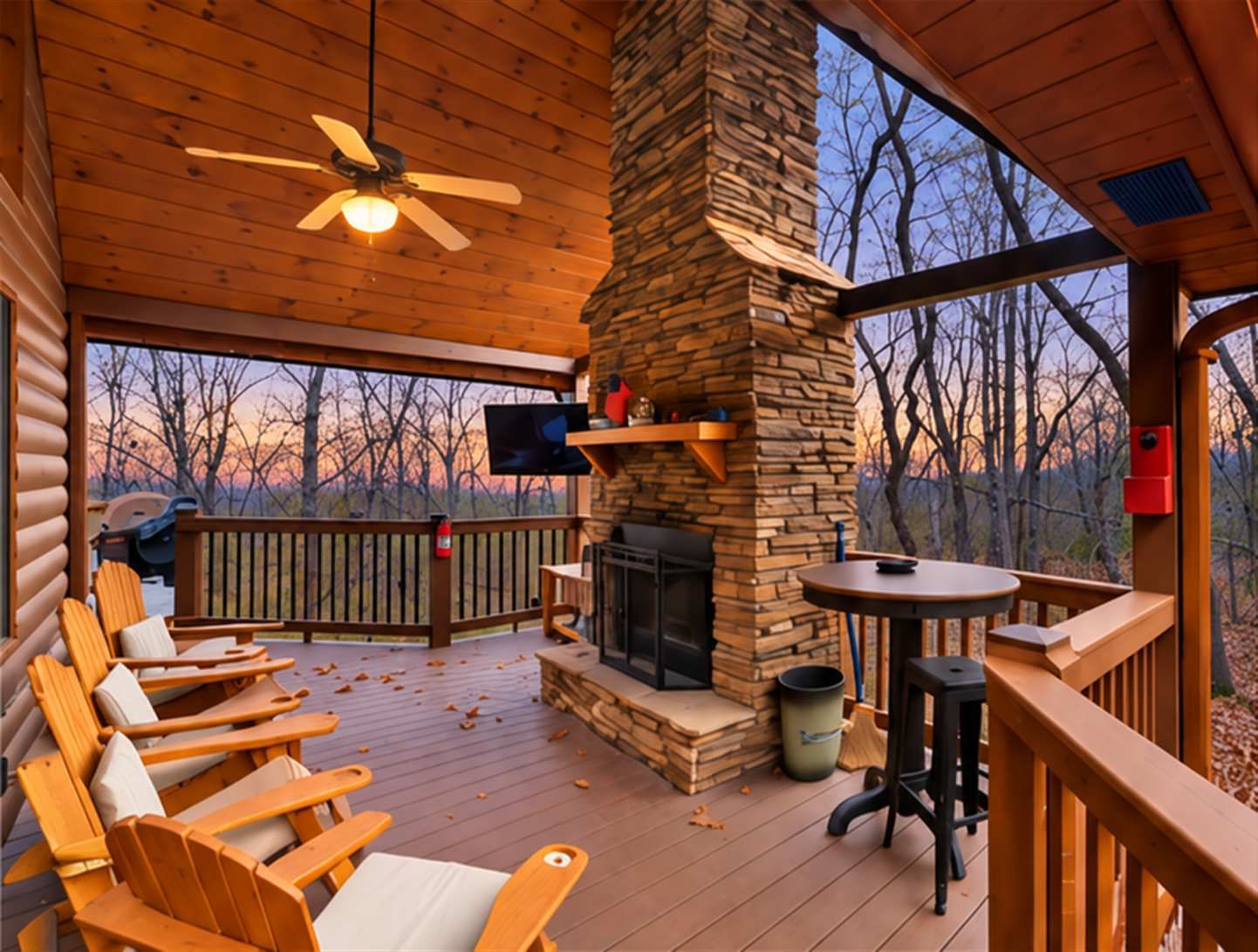 Una terraza techada con sillas Adirondack, una chimenea de piedra y un televisor.