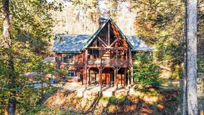 Eine Blockhütte mit Balkon, umgeben von Wald.