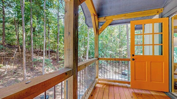 Eine Holzterrasse mit Blick auf einen Wald.