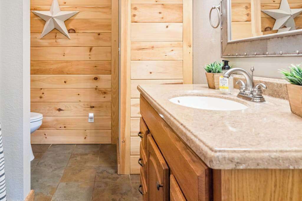 Un baño de madera con lavamanos, espejo y adornos con estrellas.