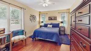 A bedroom with a bed, a chair, a dresser, and a ceiling fan. - Creekside Retreat Stay (Morganton)