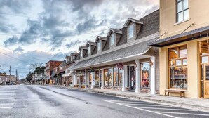 A street lined with shops, a clear sky, and a road with no visible traffic. - Creekside Retreat Stay (Morganton)