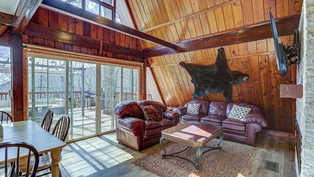 A log cabin interior with a large bear mural, a dining area, and a cozy seating arrangement. - Paradise Retreat Mountainview (Jasper)
