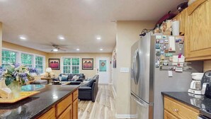 Una cucina con mobili in legno, un frigorifero e una macchina per il caffè.