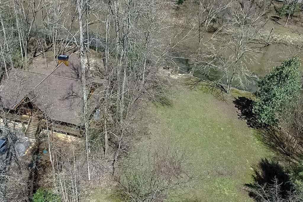 A rural property with a house, a fenced yard, and a small pond.