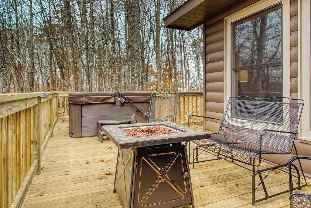 Eine Holzterrasse mit Grill, einer Bank und einem Whirlpool.