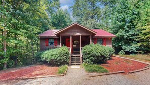 A cabin with a porch, a red door, and a gravel path leading to it. - Lazy Acres Cabin Sautee (Sautee Nacoochee)