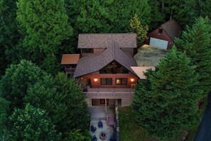 A two-story house with a deck, surrounded by dense forest. - Red Oak Luxe Mountain Cabin (Blue Ridge)