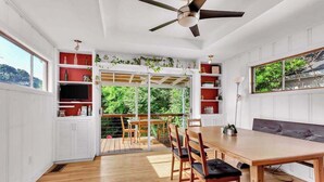 A dining area with a wooden table and chairs, a ceiling fan, and a view through a glass door to an outdoor deck. - EnDeering Retreat Stay (Atlanta)